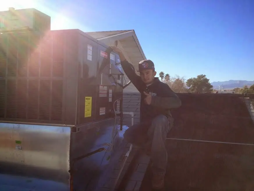 HVAC technician performing AC Tune-Up on a rooftop unit in Highwood